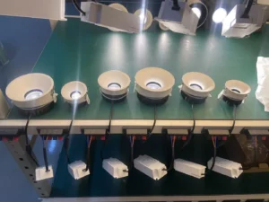 Powered LED downlights with connected driver modules on a KLM factory test bench