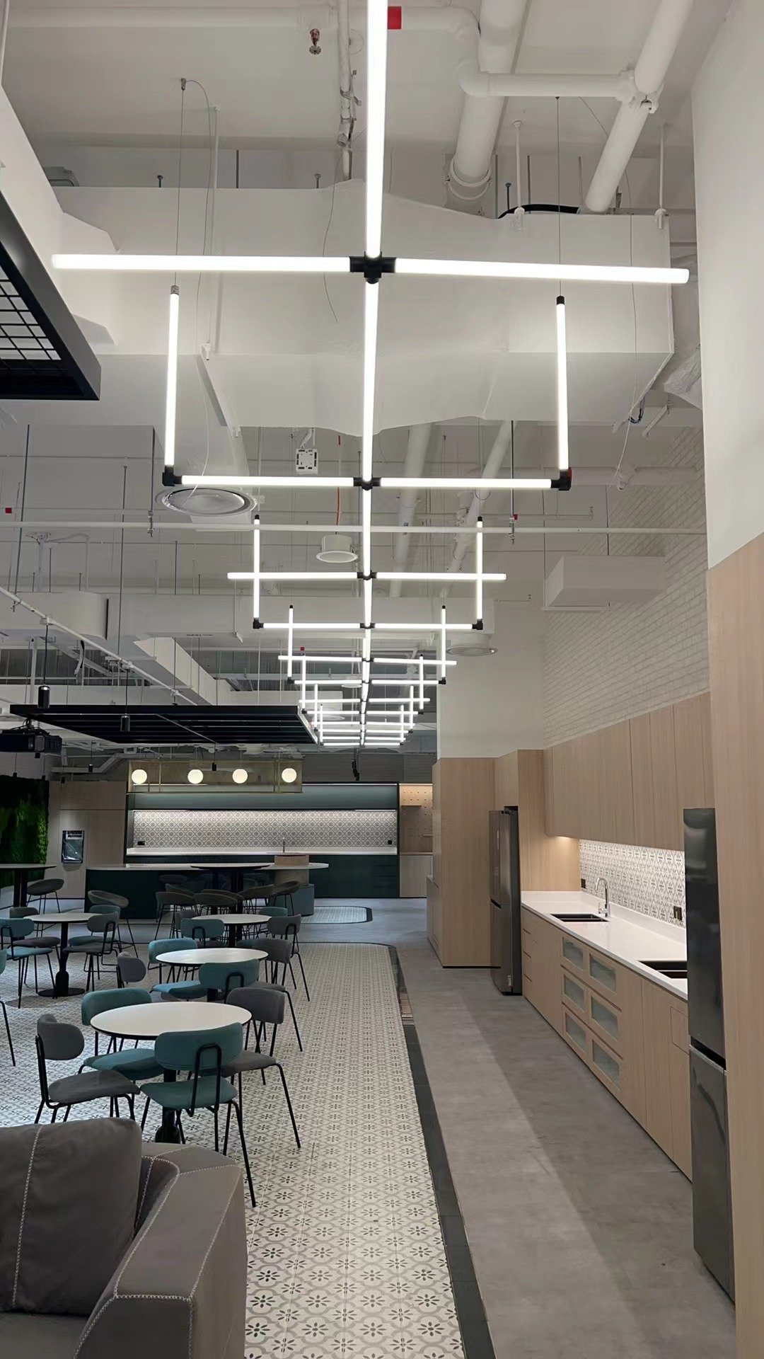Intérieur commercial avec éclairage par grille de tubes LED suspendus à 360°.