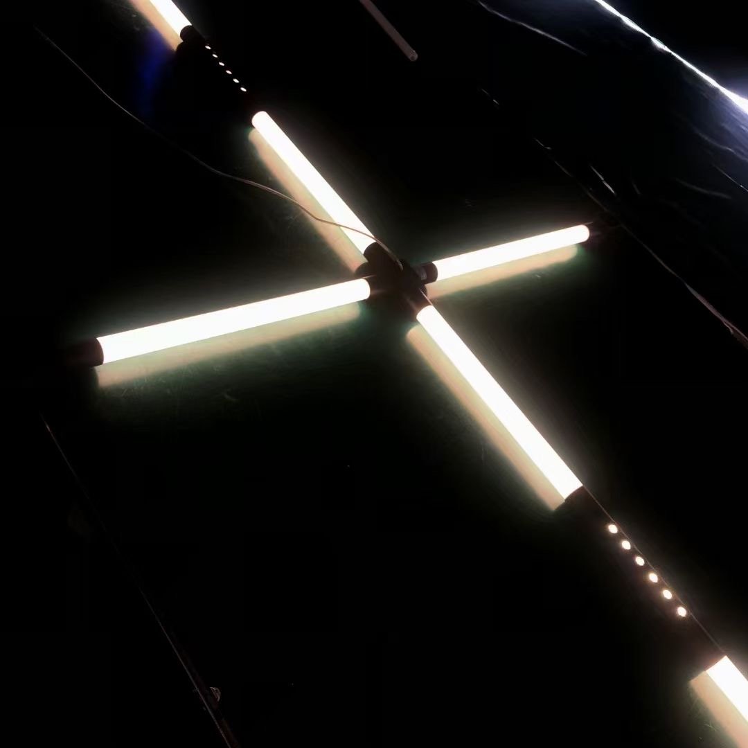 Sections de tubes LED illuminées à 360° reliées entre elles au sein d'une installation suspendue.