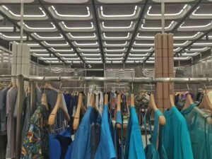 Modules lumineux tubulaires LED carrés à 360° installés de façon répétée au plafond d'un magasin.