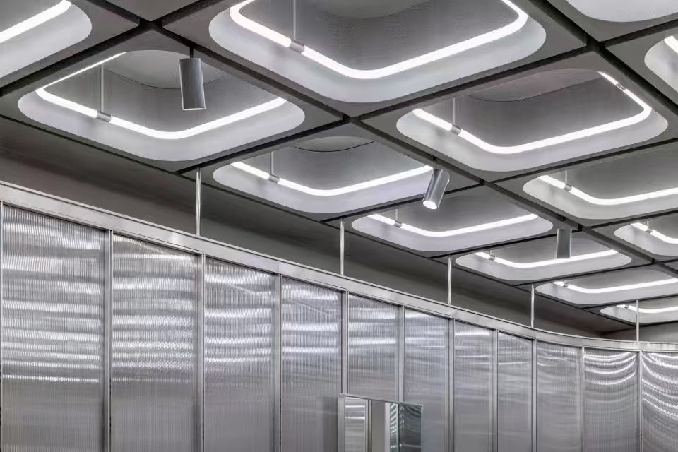 Des modules tubulaires LED carrés à 360° sont intégrés au plafond de ce même intérieur de magasin.